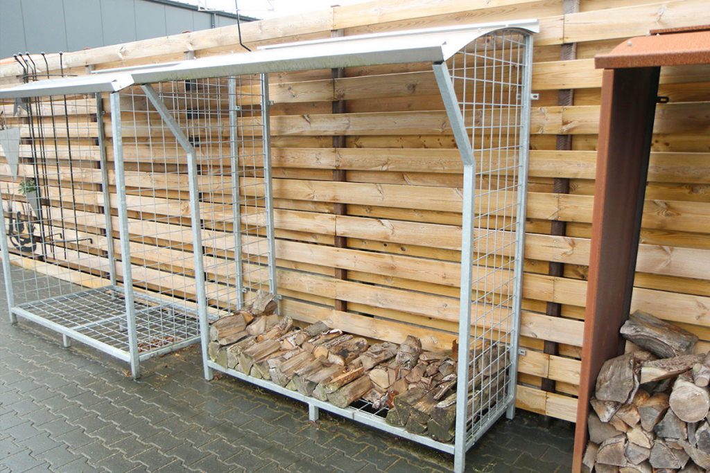 Langgerekte houtopslag geplaatst langs een schutting in de tuin